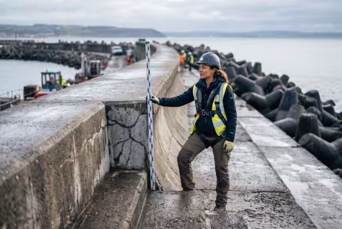 Coastal engineering hero — sea wall inspection at low tide — Program imagery, coastal engineering cluster.